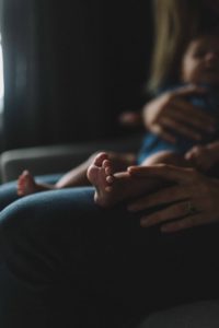 baby's feet on an adults lap