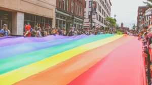 Pride parade marchers with huge rainbow banner