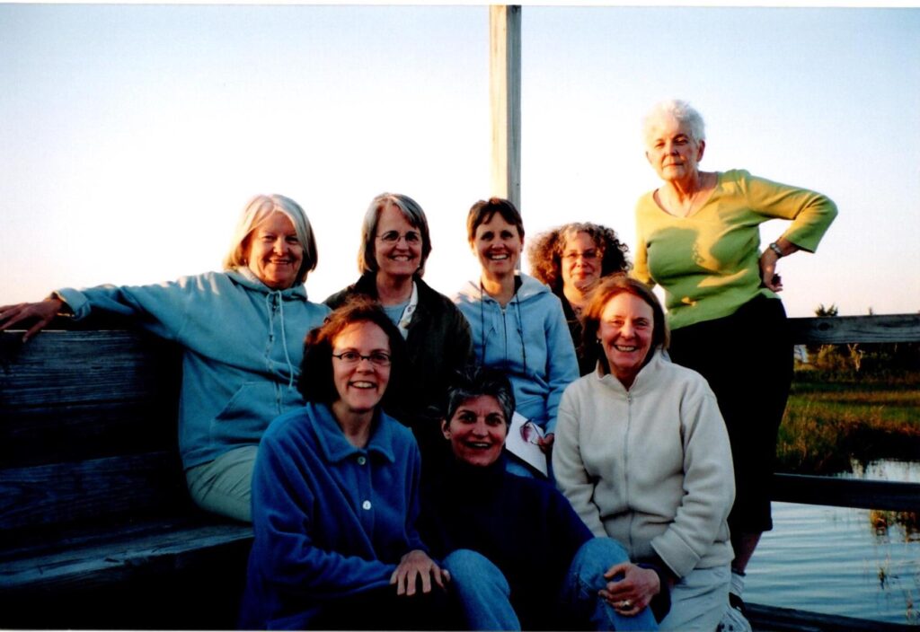 A group of women smile at the camera outside